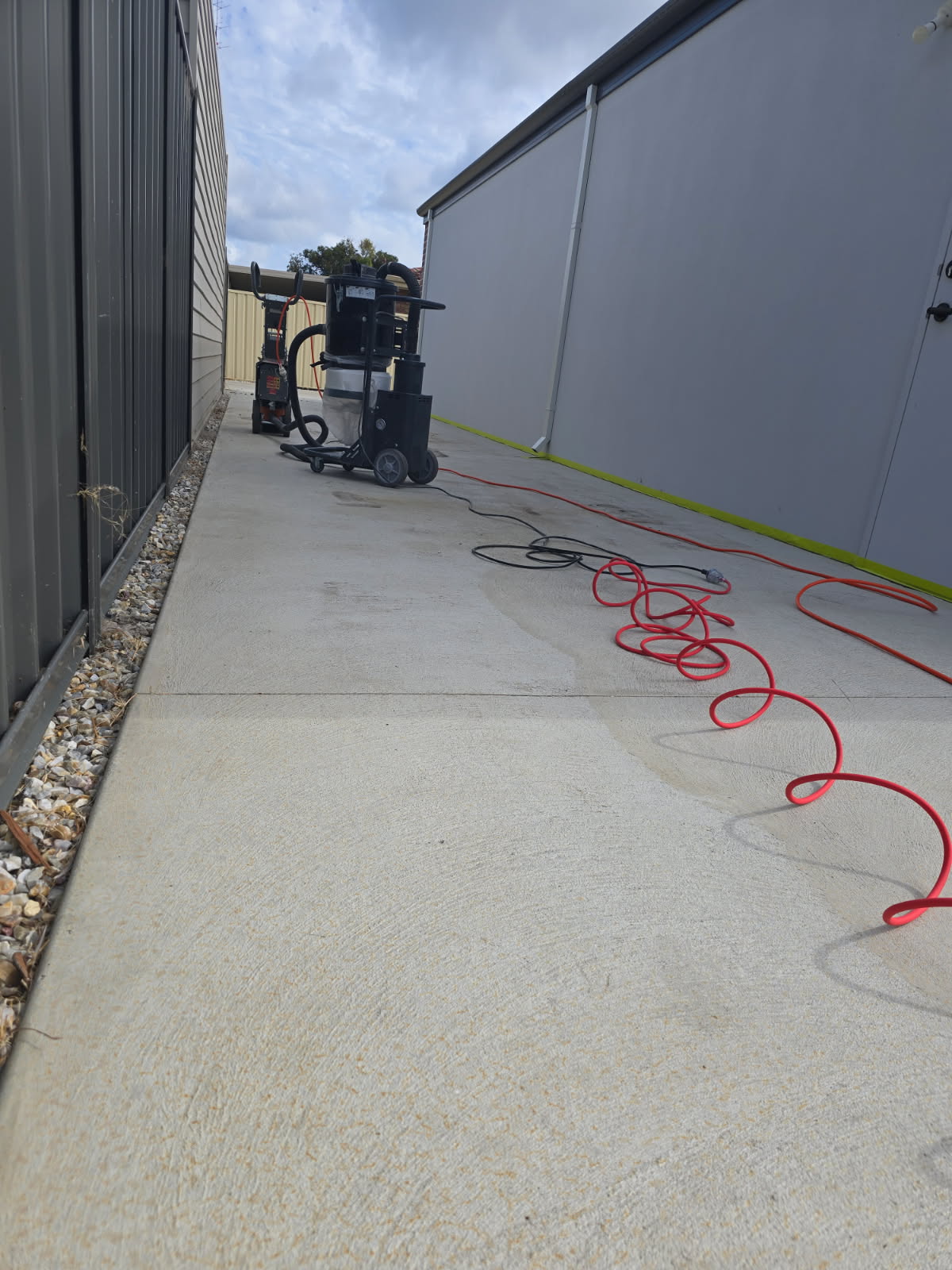 Exterior concrete path being ground with dust extraction equipment